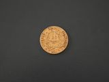 a gold coin sitting on top of a black surface