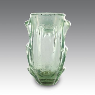 un vase en verre vert posé sur une table