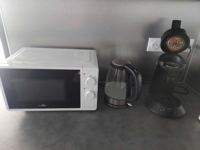 a white microwave sitting on a counter next to a coffee maker