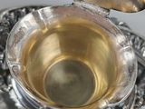 a silver plate with a silver lid and a silver spoon