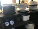 many plates and bowls on a shelf in a room