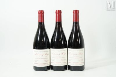 trois bouteilles de vin rouge posées l'une à côté de l'autre sur une surface blanche
