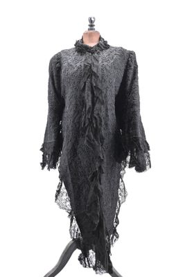 a black dress on a mannequin stand with a white background
