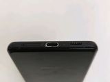 the back of a black cell phone sitting on top of a white table
