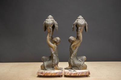 two statues of a man and a woman sitting on a table