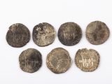 six pièces d'argent de tailles et de formes variées sur un fond blanc