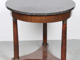 une table ronde avec un plateau en marbre noir et des pieds en bois