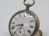 a silver pocket watch with roman numerals on it