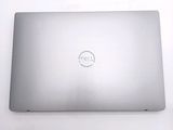 dell laptop computer sitting on a white surface with a dell logo on the screen
