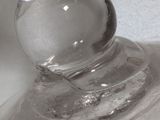 a clear glass vase with a clear base on a white surface