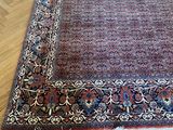 an oriental rug on a parquet floor in a living room