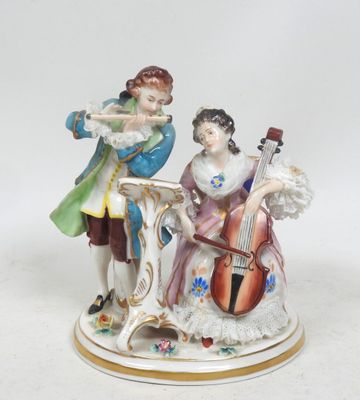 une figurine représentant un homme et une femme jouant d'un instrument de musique