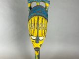 a yellow and blue mask on a black stand