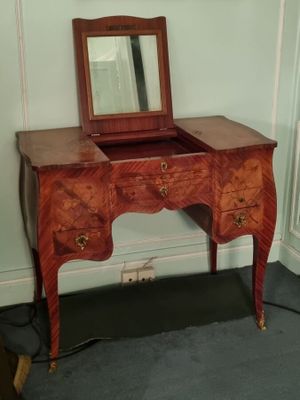 une petite coiffeuse en bois surmontée d'un miroir