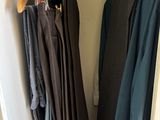 two coats hanging on a clothes rack in a closet
