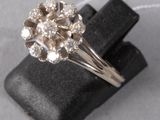 an image of a diamond ring sitting on top of a black piece of cloth
