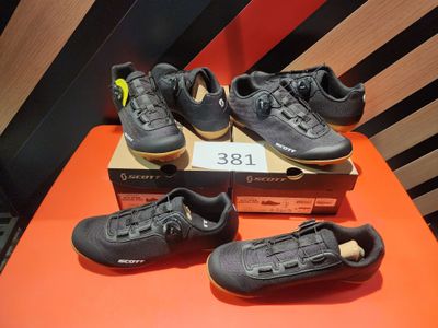 cinq paires de chaussures sont posées sur une table, accompagnées d'une étiquette de prix