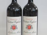 two bottles of red wine sitting next to each other on a table