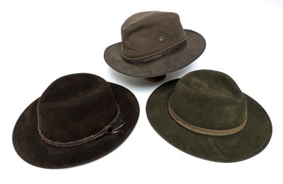 trois chapeaux sont alignés sur une surface blanche
