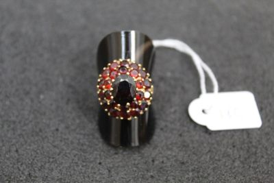 a picture of a ring with red and yellow stones on it