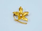 yellow flower brooch with pearl in center