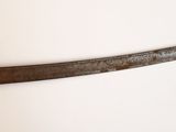 un couteau qui a l'air très ancien, accroché au mur