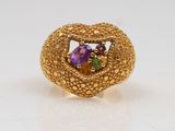 a close up of a gold ring with a purple and green stone