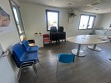 une pièce avec des chaises et une table, et un tableau accroché au mur