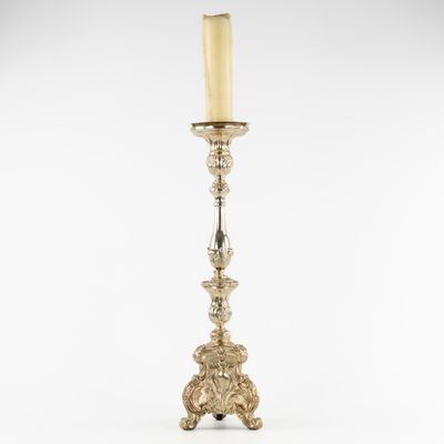 a silver candle holder with a candle on top of it