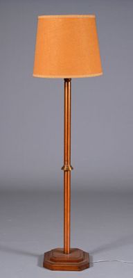 une lampe en bois surmontée d'un abat-jour marron