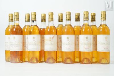 six bottles of wine are lined up in a row on a white surface