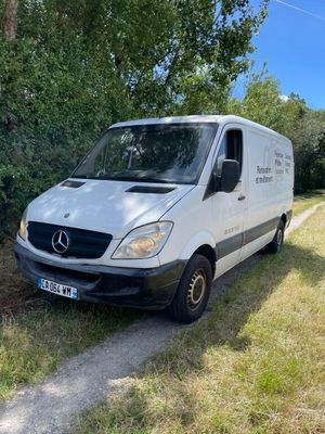 une camionnette blanche garée sur le bord d'un chemin de terre
