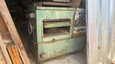 un four vert situé à l'intérieur d'un bâtiment, à côté d'un tas de bois