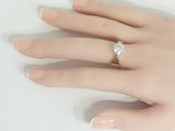a woman ' s hand with a diamond ring on it