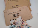 a pile of mail sitting on a table next to a cup of coffee