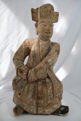 statue représentant un homme assis par terre, coiffé d'un chapeau