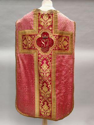 a close up of a red and gold cross on a mannequin