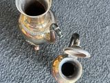une théière en argent et une théière en argent posée par terre