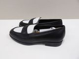 a close up of a pair of black and white shoes on a table