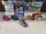 many pairs of shoes that are on a bed