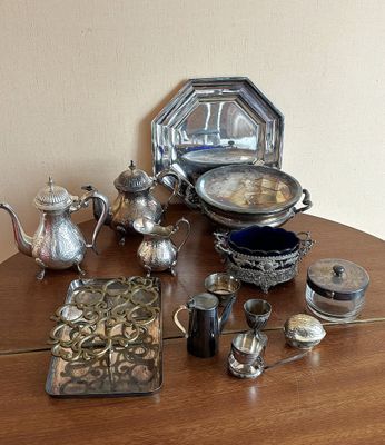 une table en bois sur laquelle sont posés de nombreux objets en argent