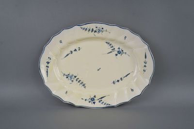 blue and white plate with blue flowers on it on a gray surface