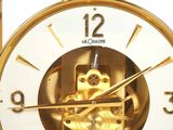 a gold clock with an owl inside of it