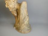 une statue représentant un homme assis sur une table