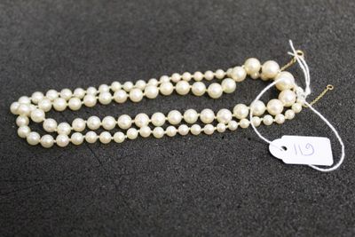 a close up of a white pearl necklace with a tag on it