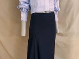 un mannequin vêtu d'une jupe et d'une chemise, posé sur un socle