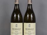 two bottles of wine sitting on top of a table next to each other
