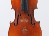 un vieux violon posé sur une surface blanche