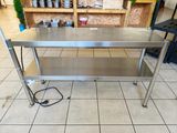 a stainless steel table that is on a tile floor
