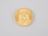 a close up of a gold coin on a white surface